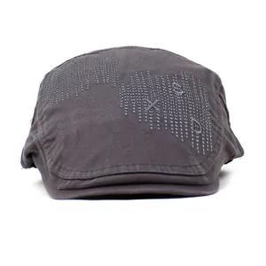 Détail du béret en coton gris foncé avec broderie SXD et texture en tissu sergé mat