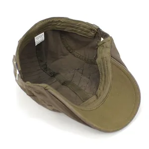 Detail view of cotton flat cap featuring diamond quilted lining and metal adjustment buckle