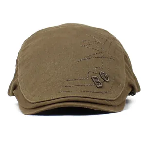 Detailed close-up of BG letter embroidery on brown cotton twill flat cap for men
