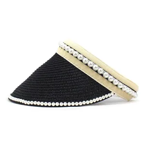 Detailed view of black woven straw visor brim with elegant white pearl bead decorations