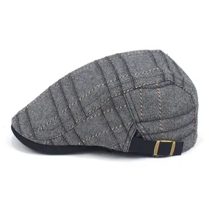 Detail view of grey striped beret hat with adjustable black side buckle and metal loop