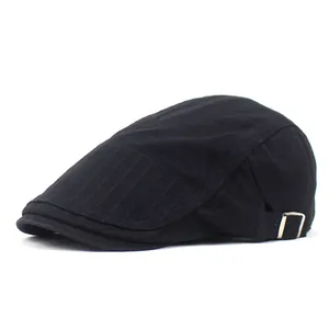 Detail of black cotton flat cap featuring reinforced visor stitching and metal side buckle