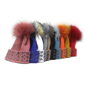 Collection of knitted beanies with faux fur pom-poms and shimmering star print patterns
