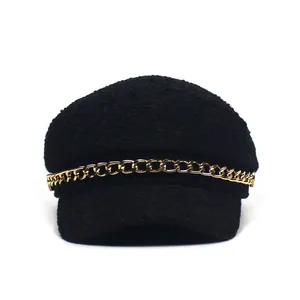 Classic black tweed newsboy cap with a vintage gold chain accent on a white background