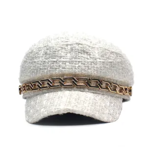 White tweed baker boy hat with a gold chunky chain accent and flat top silhouette