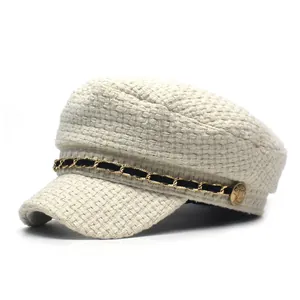 Elegant beige tweed newsboy cap with gold chain accent and soft woven texture