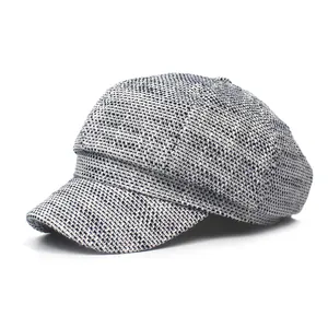 Classic black and white tweed newsboy cap for women featuring textured woven fabric style