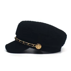 Detail of tweed newsboy cap with golden metal chain and decorative embossed button