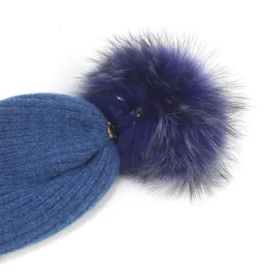 Gros plan sur le bonnet en tricot torsadé avec pompon en fausse fourrure