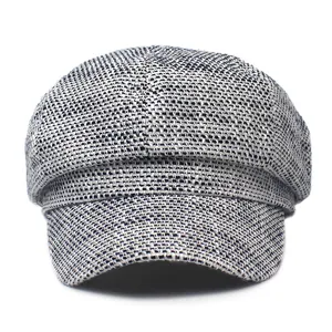 Detailed texture of grey tweed newsboy cap fabric with woven octagonal pattern
