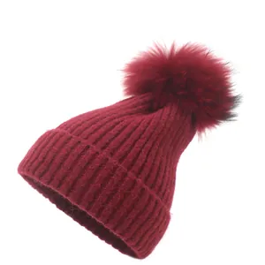 Bonnet d'hiver en tricot côtelé bordeaux pour femme avec un grand pompon en fourrure