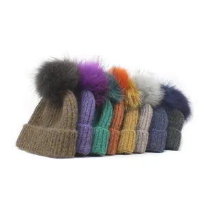 Detail view showing multi-colored chunky knit beanies with soft fluffy pom-poms