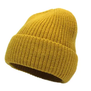 Detailed close-up of mustard yellow ribbed knit beanie with stylish folded cuff