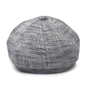 Detailed view of black and white salt and pepper textured newsboy cap fabric