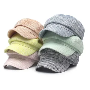 Detailed view of colorful octagonal baker boy hats with woven texture in various soft hues