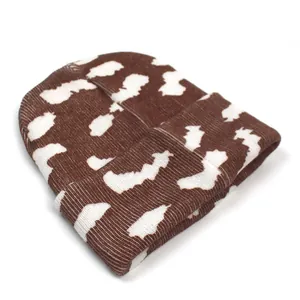 Détail du bonnet en tricot à motif nuage marron et blanc avec revers côtelé