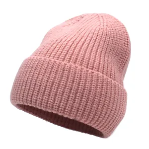 Detailed close-up showing the soft ribbed knit texture and cuff of the pink beanie