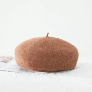 Close-up of caramel wool beret showing plush texture and classic top detail