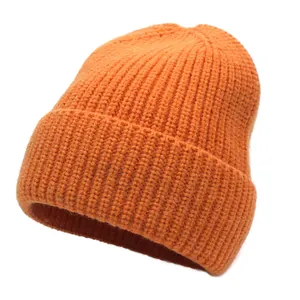Detail of bright orange knit beanie showing thick vertical ribbing and wide folded cuff