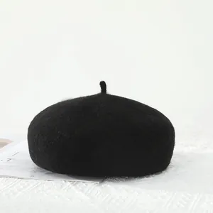 Detailed texture of a classic black wool beret on white lace fabric with magazines