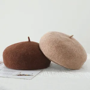 Detail of wool blend beret hats in dark brown and camel for autumn winter season