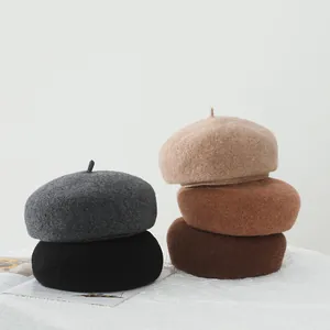 Detailed stack of wool beret hats in five autumn colors including beige and grey