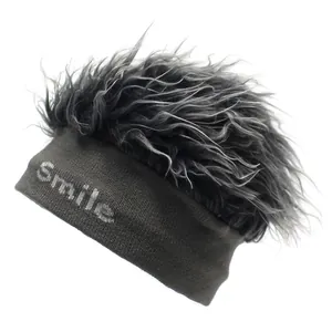 Detailansicht der grauen Strickmütze mit Smile-Schriftzug und grauem Kunsthaar-Aufsatz