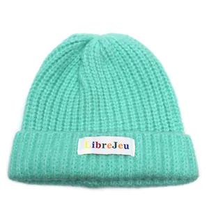 Dettaglio del berretto in maglia a coste verde menta con toppa colorata LibreJeu