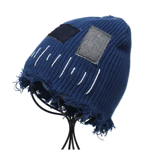 Distressed dark blue ribbed beanie with denim patches and vintage frayed edges