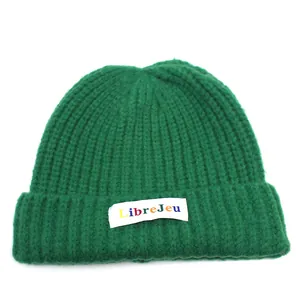 Dettaglio del berretto in maglia verde scuro con etichetta tessuta colorata LibreJeu