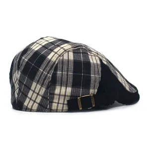 Detail of classic black and white plaid ivy cap with adjustable gold buckle strap