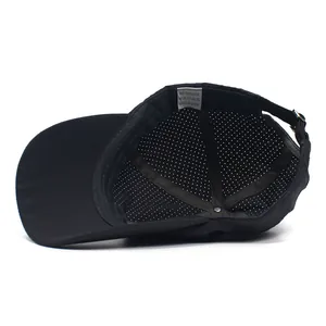 Detail view of breathable mesh lining, wash label and metal buckle on black golf cap