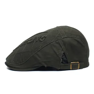 Detail of army green quilted cotton newsboy cap featuring side letter embroidery and brass buckle