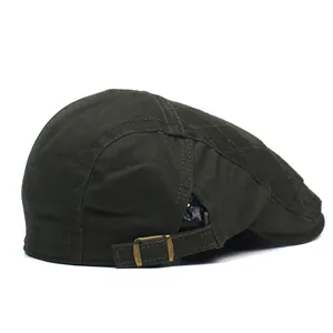 Detail of dark green cotton flat cap featuring diamond quilting and brass side buckle