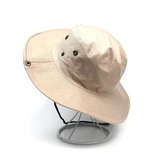 Detail of beige wide-brim sun hat with bronze ventilation eyelets and windproof drawstring