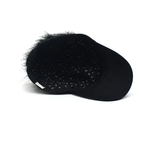 Detail view of the black baseball cap showing the wig hair and polka dot lining