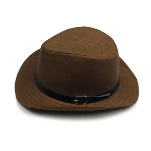 Detailed close-up of brown woven straw hat with black leather strap and silver buckle