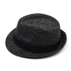 Close-up of grey plaid fedora hat with a black ribbon band and textured wool fabric