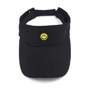 Close-up of black sun visor with yellow emoji embroidery and adjustable velcro strap