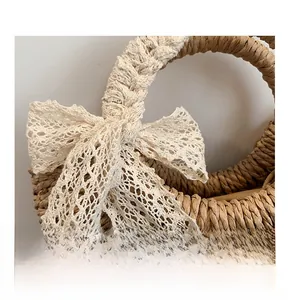 Close-up of natural straw weave texture and delicate white lace bow on the handbag