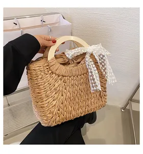 Close-up of straw woven tote with wooden handles and delicate white lace detailing