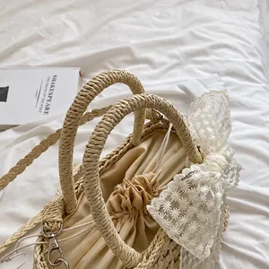 Détail du sac à main en paille tissée avec dentelle blanche et accents floraux
