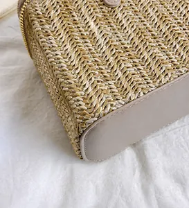 Gros plan sur le tissage beige et la base en cuir marron avec fermeture éclair dorée