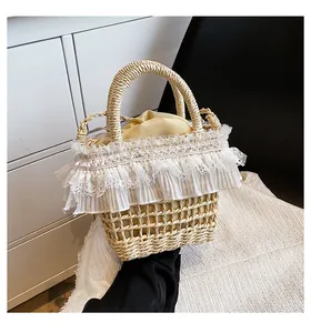 Détail du sac seau en paille avec bordure en dentelle blanche et doublure à cordon