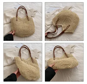Dettaglio della borsa tote in paglia intrecciata con manici in pelle marrone e rivetti