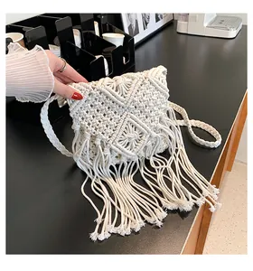 Dettaglio della borsa macramè in cotone crema con motivi a diamante e lunghe nappe intrecciate