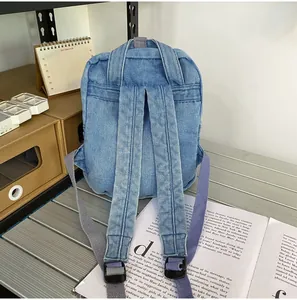 Details des hellblauen Denim-Rucksacks mit verstellbaren grauen Trägern und Vintage-Stil