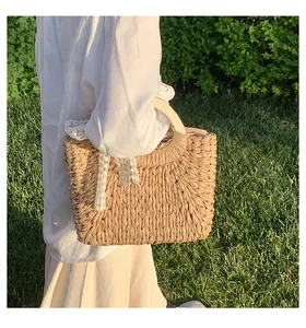 Detailed close-up of straw woven tote with wooden handles and floral lace bow decoration
