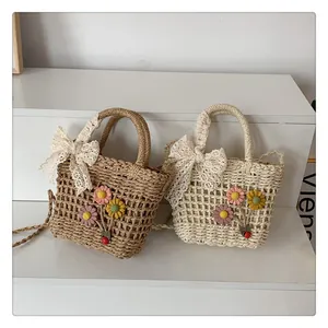 Close-up of handmade straw bags with floral daisy appliques and white lace bow details