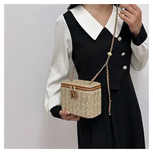 Détail d'un petit sac boîte en paille tissée avec double fermeture éclair dorée